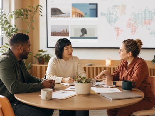 A product owner, designer, and operations lead planning together in a bright studio